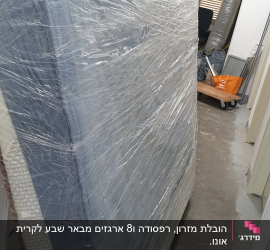 מזרן עטוף בניילון במסדרון צר עם עגלת הובלה